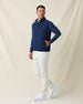 Men's Delta 2.0 Quilted Hybrid Vest in New Indigo, full length side view on model featuring a navy quilted front panel with full zip closure, layered over a navy long sleeve shirt, paired with white pants and white shoes