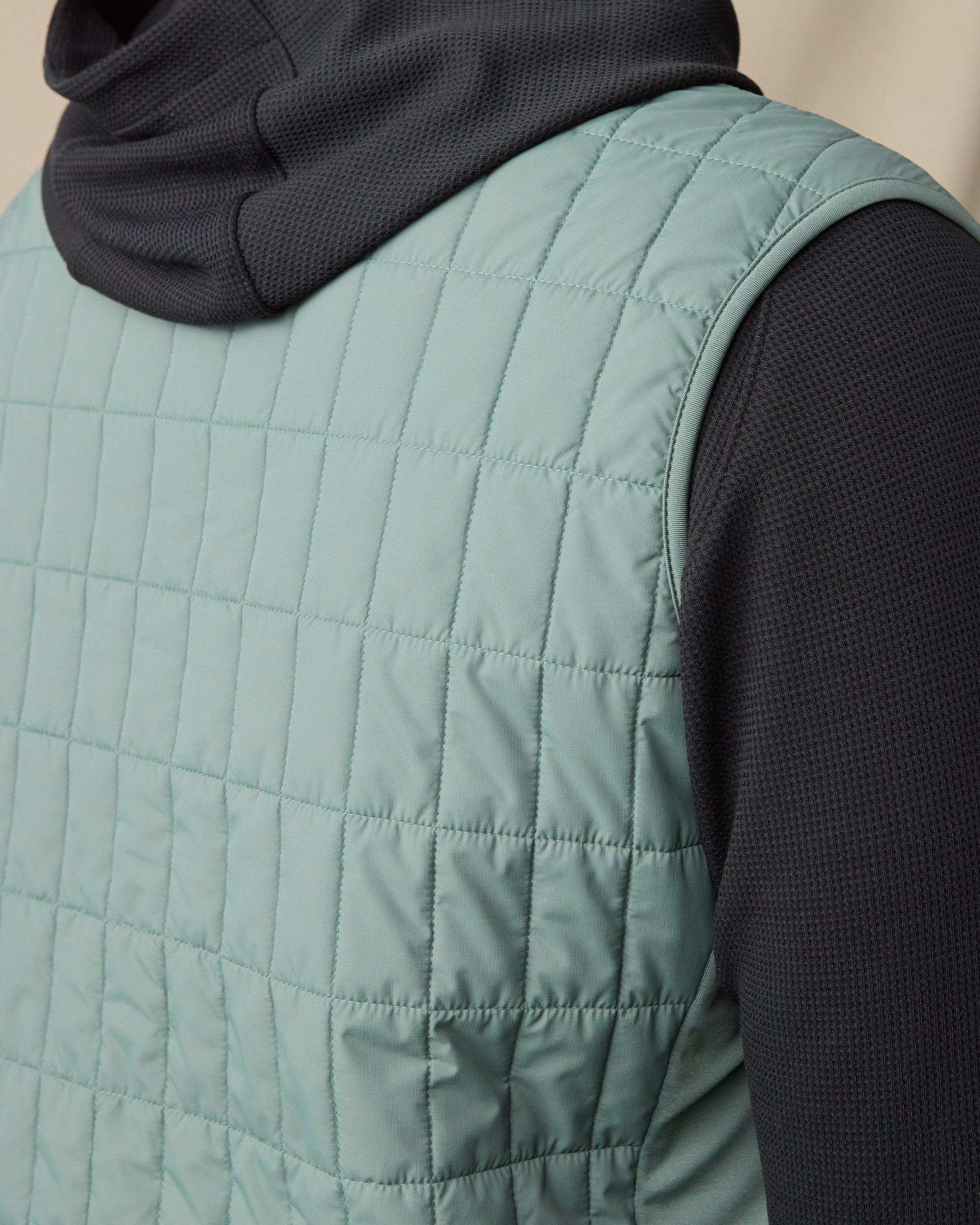 Back view of the Big Horn Quilted Vest in Dark Forest, highlighting the grid quilting and stretch side panel.