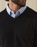 Men's Ballesteros V-Neck Sweater in Black, on model front close-up view featuring v-neck detail and fine knit texture worn over a light blue polo