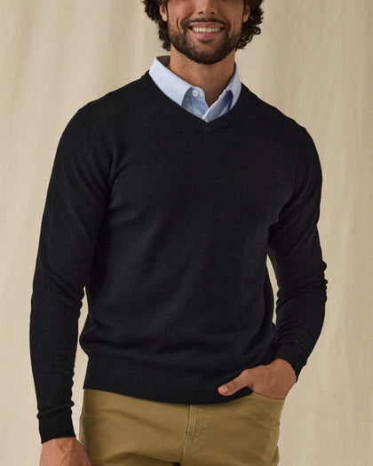 Men's Ballesteros V-Neck Sweater in Black, on model front view featuring a black fine knit v-neck sweater with ribbed cuffs worn over a light blue polo