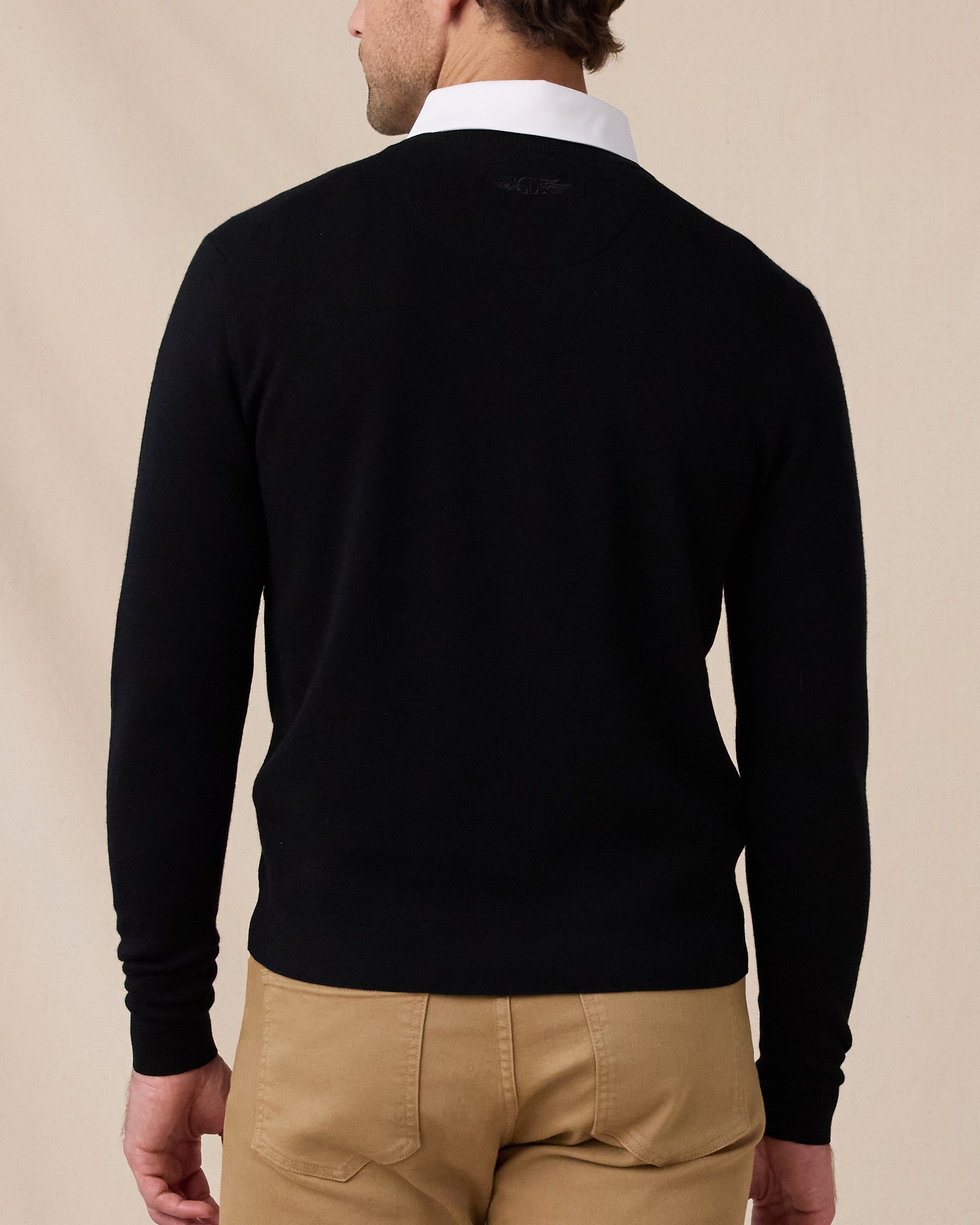 Back view of the black Connery V-Neck Sweater featuring a subtle tonal logo below the collar.