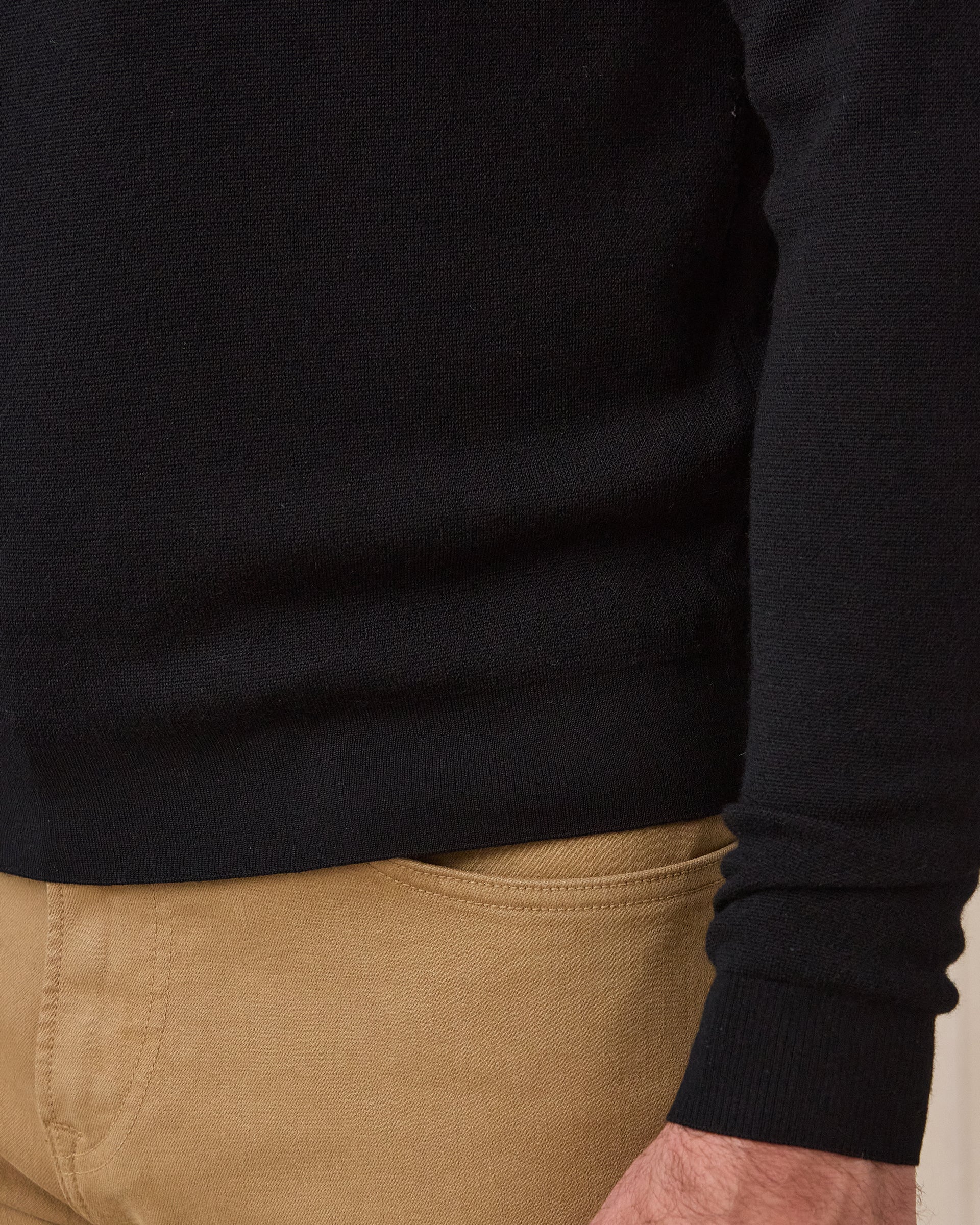 Close-up of the black Connery V-Neck Sweater showing the fine knit fabric, ribbed hem, and ribbed sleeve cuff.