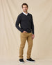Man wearing the Dark Grey Heather Connery V-Neck Sweater over a white collared shirt, paired with tan pants and black sneakers.