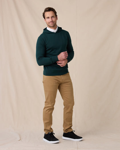 Model wearing the Crenshaw Reversible Sweater Hoodie in Dark Forest with tan pants and black sneakers.