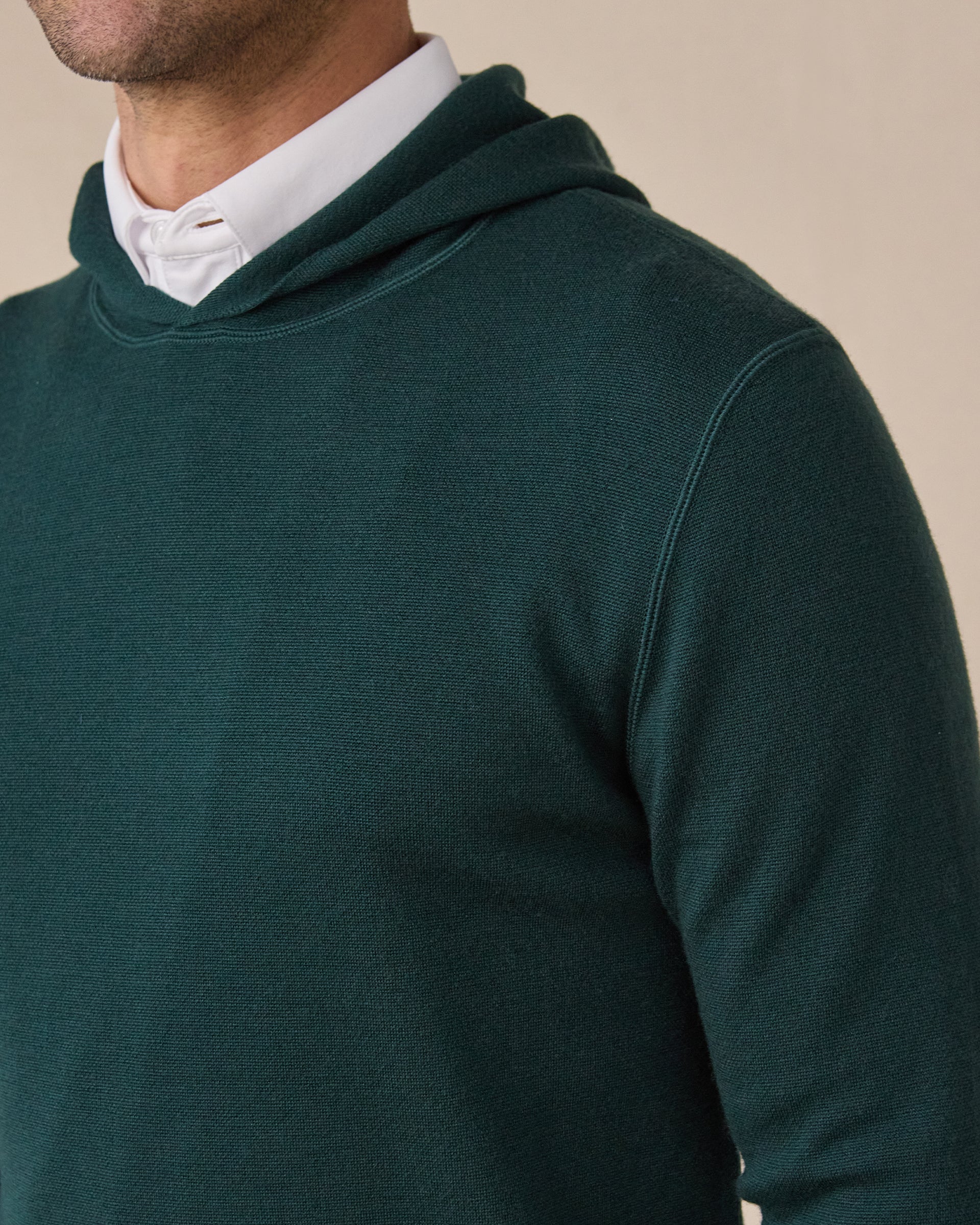 Close-up of the Crenshaw Reversible Sweater Hoodie in Dark Forest highlighting the smooth knit texture, hood, and shoulder seam.