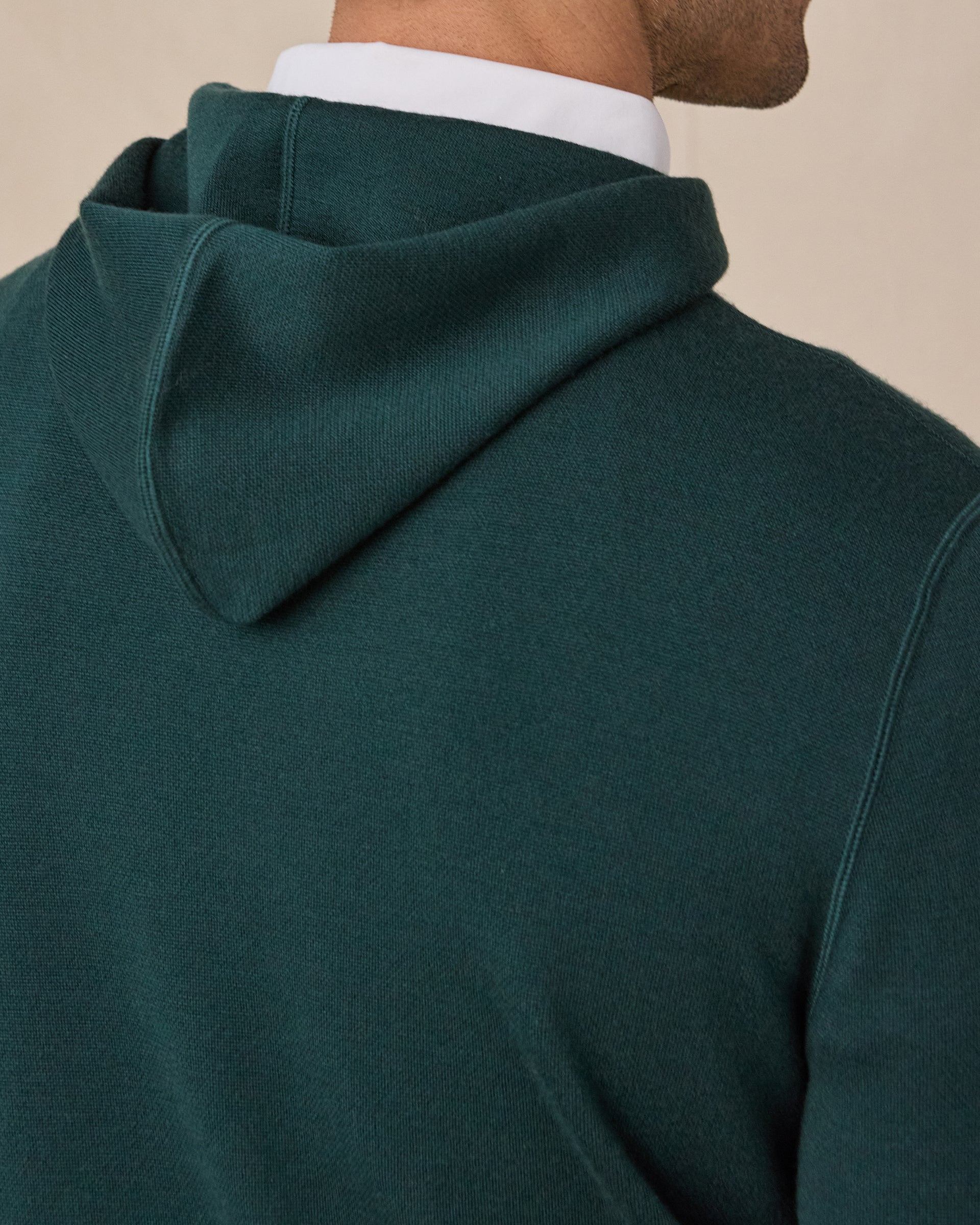 Close-up of the Crenshaw Reversible Sweater Hoodie in Dark Forest highlighting the hood construction, knit texture, and back shoulder detailing.