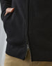 Men's Sarazen Knit Bomber in Black, on model close-up view featuring fine knit texture detail, side pocket with hand inserted, and gunmetal zipper hardware