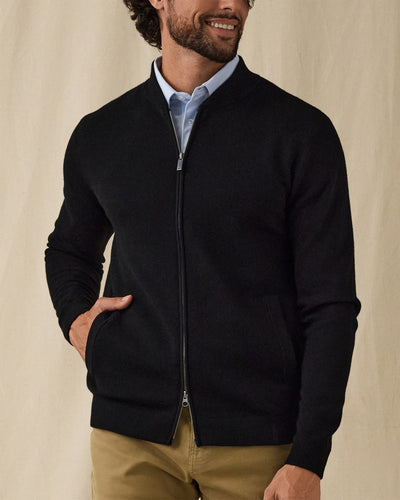 Men's Sarazen Knit Bomber in Black, on model front view featuring a full-zip black fine knit bomber with stand collar and side pocket with hand inserted worn over a light blue polo