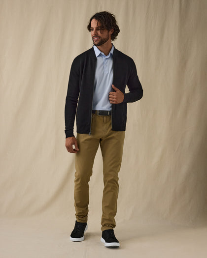 Men's Sarazen Knit Bomber in Black, on model front full-length view featuring an open zip black fine knit bomber with stand collar worn over a light blue polo paired with khaki pants and shoes