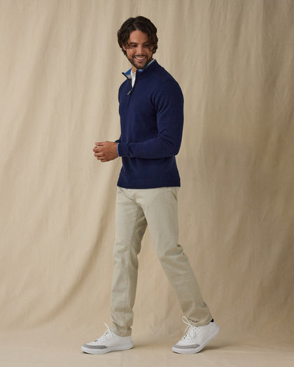 Men's Lakeside Quarter Zip Sweater in New Indigo, full front view on model featuring a solid navy knit body with light blue tipped collar and cuffs, layered over a white polo, worn with light grey pants and white golf shoes
