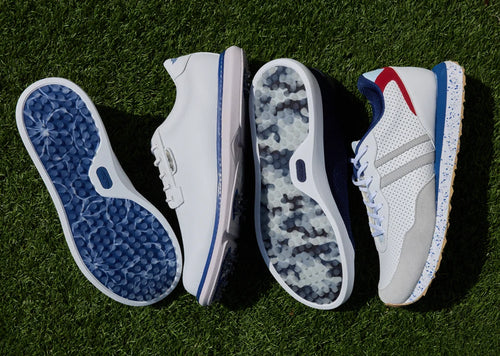 Four athletic shoes arranged side by side on green grass, showing the outsole, side profile, camouflage-patterned sole, and upper view of a white sneaker with blue and red accents.