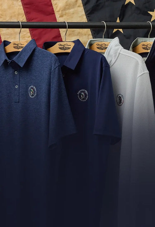 126th U.S. Open apparel displayed on a clothing rack in front of a vintage American flag backdrop