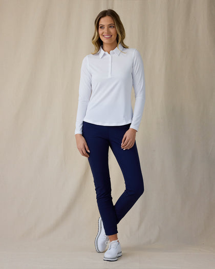 Midday Long Sleeve Polo in White, full length front view on model showing a fitted collared long sleeve polo with a half-button neckline, paired with navy pants and white golf shoes