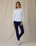 Midday Long Sleeve Polo in White, full length front view on model showing a fitted collared long sleeve polo with a half-button neckline, paired with navy pants and white golf shoes