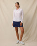 Full outfit view of the Midday Long Sleeve Polo in Pale Pink worn untucked with a navy golf skort