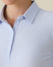 Women's Midday Long Sleeve Polo in Powder, close-up detail view featuring the spread collar and three-button placket with branded snap buttons on a light blue polo
