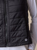 Cloud Vest in Black, close-up front view on model featuring the horizontal quilted pattern, tonal zipper, and Straight Down embroidered logo at the hem