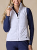 Cloud Vest in White, front view on model featuring a white quilted full-zip vest with mock neck collar being held open at the collar styled with a navy long sleeve top and navy pants