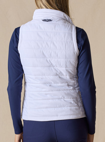 Cloud Vest in White, back view on model featuring a white quilted vest with Straight Down embroidered logo at the center back neck styled with a navy long sleeve top and navy pants