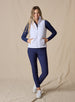 Cloud Vest in White, full length front view on model featuring a white quilted full-zip vest with mock neck collar and front pockets with hands inserted styled with a navy long sleeve top, navy pants, and white shoes