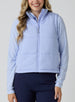 Women's Sandy Vest in Lavender, front view on model featuring a light purple quilted puffer vest layered over a patterned long sleeve top, paired with navy pants