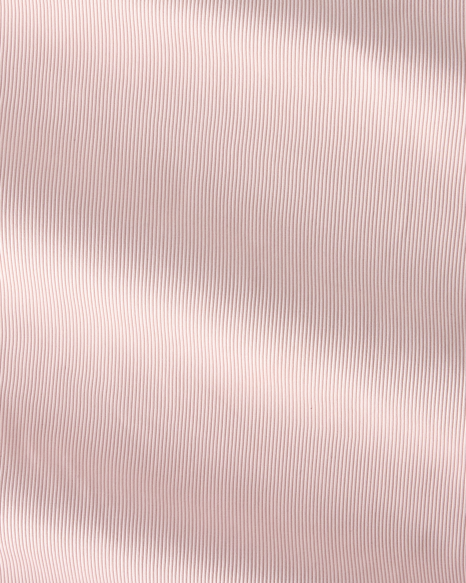 A close-up of a light blush pink fabric with a fine vertical ribbed texture and soft, diagonal folds.
