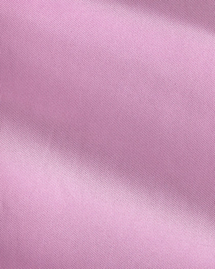 A close-up of light pink fabric with a fine woven texture and soft diagonal folds.