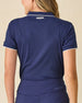 Women's Sindy Rib Knit Polo in New Indigo, back view on model featuring a ribbed knit with Straight Down logo embroidered at center back neck, paired with navy pants