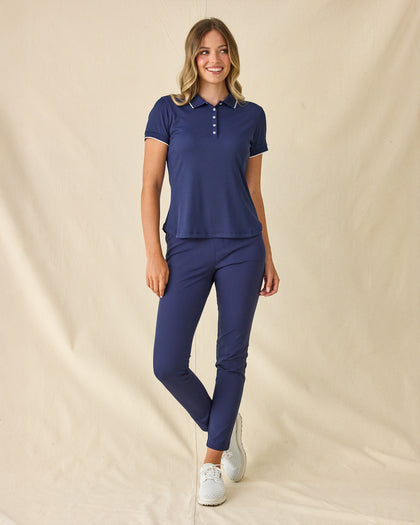 Women's Sindy Rib Knit Polo in New Indigo, full length front view on model featuring a ribbed knit with white tipped collar and cuffs, paired with navy pants and white shoes