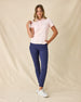 Women's Sindy Rib Knit Polo in Pearl, full length model view featuring a light pink short sleeve ribbed knit polo with a spread collar, styled with navy pants and white shoes