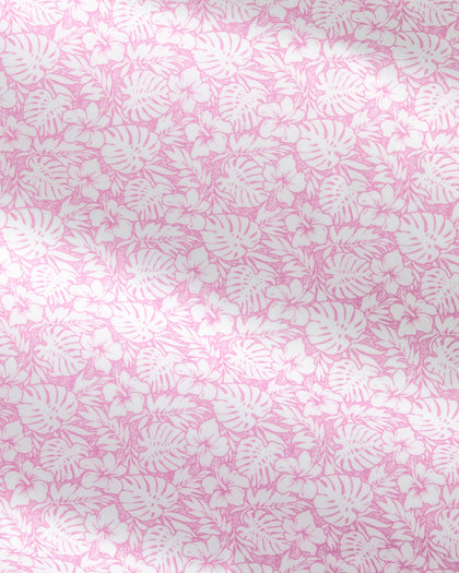 Pink and white tropical floral pattern with monstera leaves and small flowers, shown as a close-up fabric or wallpaper texture.