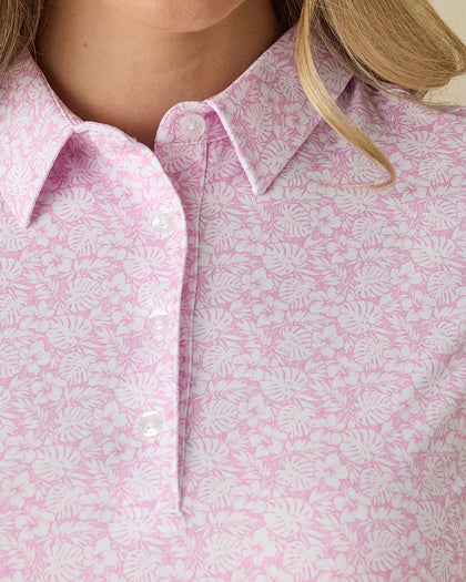 Women's Kiana Polo in Pink Floyd, close-up front view on model highlighting the pink and white allover tropical floral and leaf print