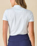 Dog Mom Polo in Coastal, back view worn by a model paired with navy pants, showing the light blue and white allover dog print pattern with Straight Down logo at the back collar