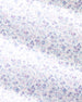A close-up of a white fabric or paper surface covered in a dense, hand-drawn pattern of small palm trees and tropical motifs in blue and pink lines.