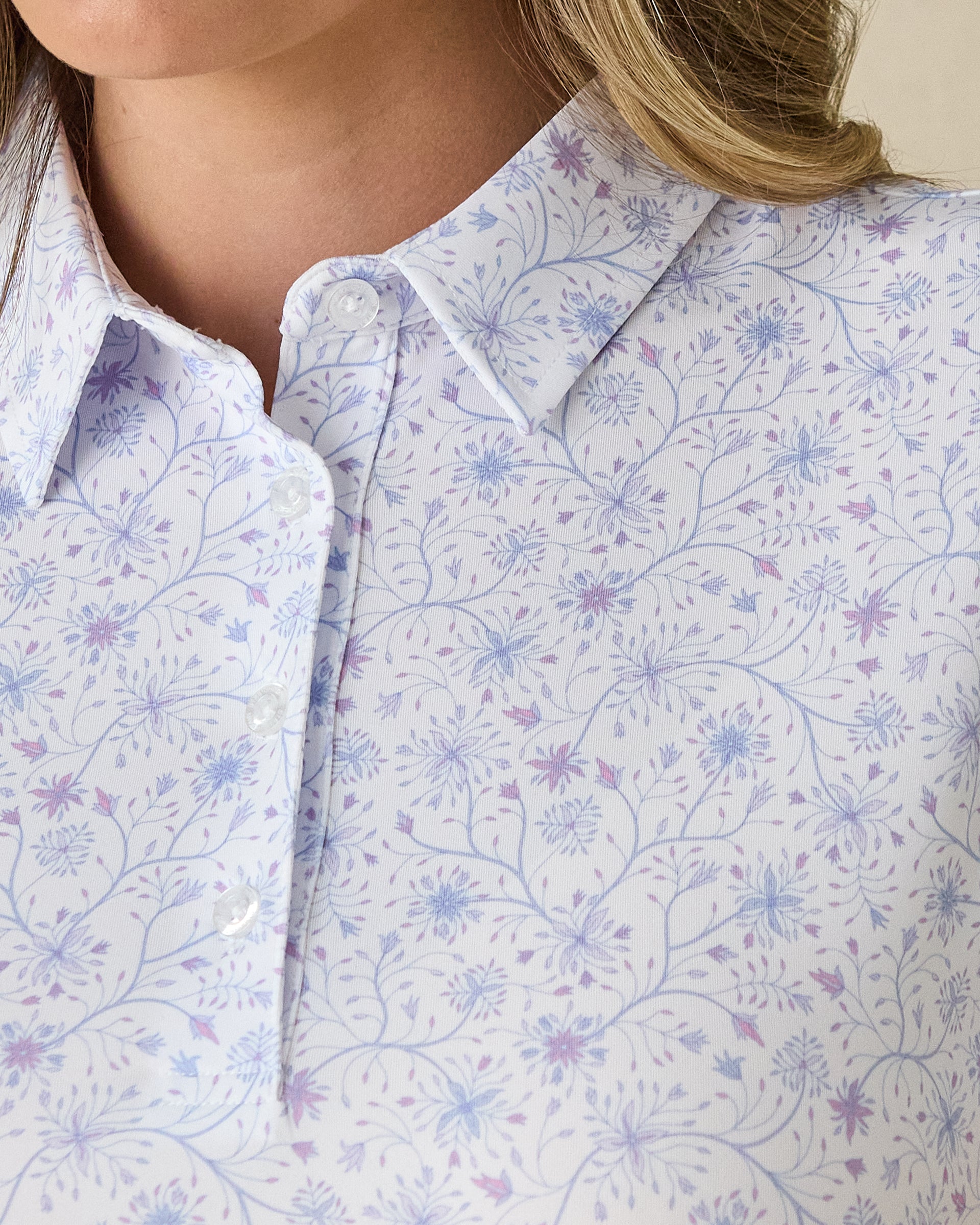 Women's Mariette Polo in Pink Floyd, close-up front view on model highlighting the blue and purple vine floral print