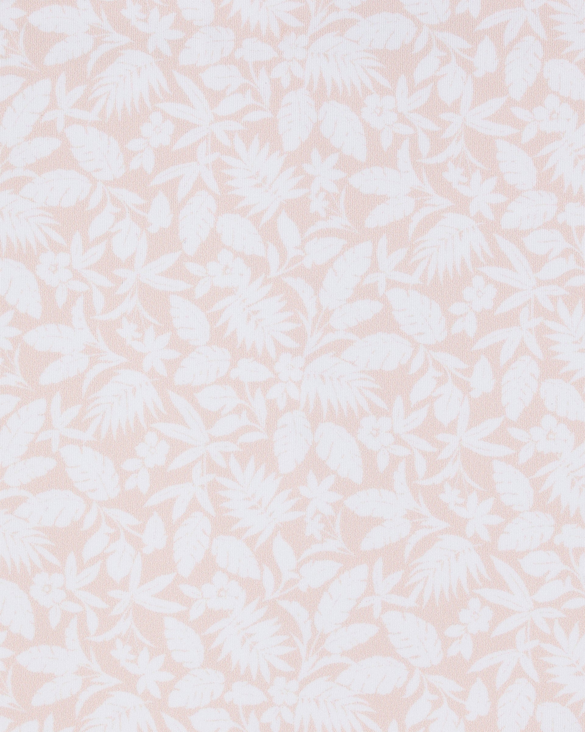 Close-up of the Huli Polo in Peach fabric featuring a tonal peach and white print of tropical leaves and flowers.