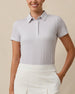 Front view of a woman wearing the Martini Girl Polo in Lemongrass with a white pleated skort, showing the small allover martini glass print.