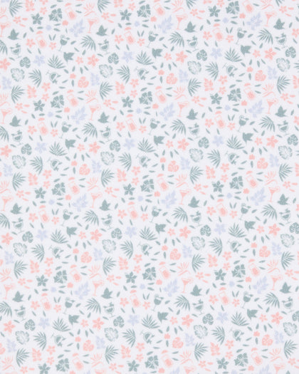 Close-up of the Palm Island Polo in Lemongrass fabric featuring a pastel print of palm leaves, flowers, tropical foliage, and cocktail motifs.