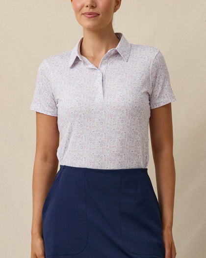 Model wearing the Lanakai Polo in Cosmic, featuring a white base with a pastel Hawaiian block-inspired print