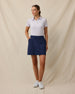 Model wearing the Lanakai Polo in Cosmic tucked into a navy golf skort