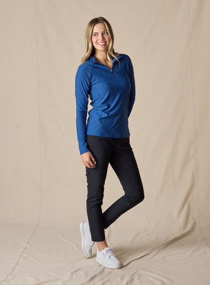 Straight Down Women's Claire Quarter Zip in Indigo, full length front view on model featuring a heathered blue long sleeve quarter zip pullover with raglan sleeves, paired with black pants and white shoes