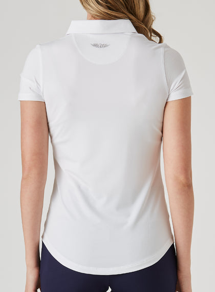 Women's Abbot Polo in White, back view on model featuring a white short-sleeve polo with Straight Down logo at upper back and curved hem, paired with navy pants