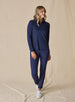Women's Aero Quarter Zip in New Indigo, full body front view on model featuring a navy micro-texture long sleeve pullover with a quarter-zip neckline paired with navy pants and white golf shoes