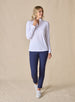 Women's Aero Quarter Zip in White, full-length front view on model featuring a clean white performance fabric with a quarter-zip neckline and long sleeves, paired with navy pants and white shoes
