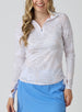 Straight Down Women's Flora Quarter Zip in White, front view on model featuring a white long sleeve quarter zip pullover with an allover neutral tropical leaf print and adjustable side ruching, paired with a blue skort