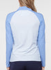 Back view of a woman wearing a light blue quarter-zip pullover with contrasting blue raglan sleeves, light body, and high collar
