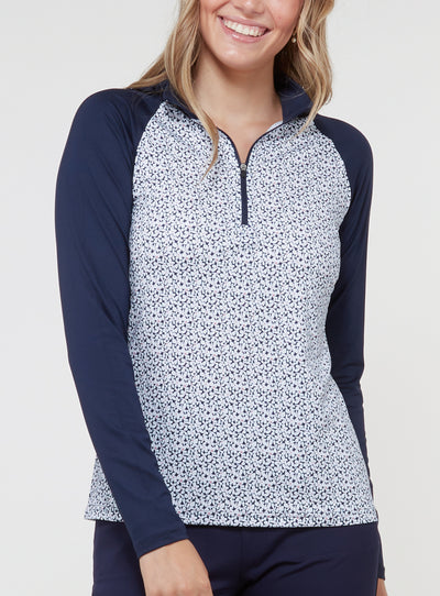Straight Down Women's Daizee Quarter Zip in New Indigo, on model front view showing white floral print body with solid navy raglan sleeves and quarter zip closure paired with navy pants