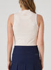 Orchard Sleeveless Polo in Bellini, back view on model featuring a peach sleeveless polo with an allover white delicate leaf and vine print, white armhole trim, and Straight Down logo at the upper back, paired with a navy pleated skort