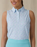 Women's Costa Rica Sleeveless Polo in Green Stone, front on-model view from the waist up featuring a white sleeveless polo with an allover small floral and leaf print in blue and mint green tones, spread collar, and three-button placket, paired with a mint green skirt