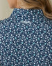 Women's Flores Sleeveless Polo in New Indigo, close-up back on-model view highlighting the Straight Down logo embroidered at the upper back featuring an allover small floral print in white and mint green tones on a navy base
